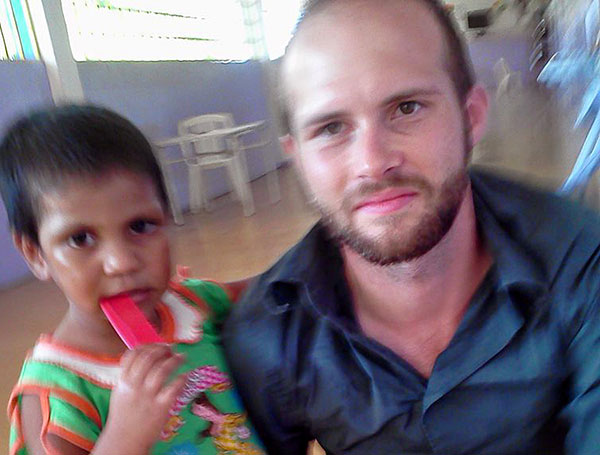 In a smeary, candid shot, Zach has his arm around a young boy, who is chewing on a comb.