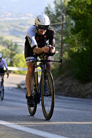 Zach in full gear coming around a bend in the road on his Ironman competition bike.